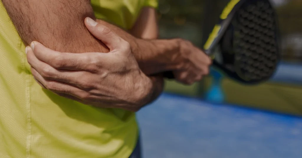 Why Does Pain Keep Coming Back? When Recurring Pain Deserves an Evaluation Person holding a painful elbow while holding a tennis racket